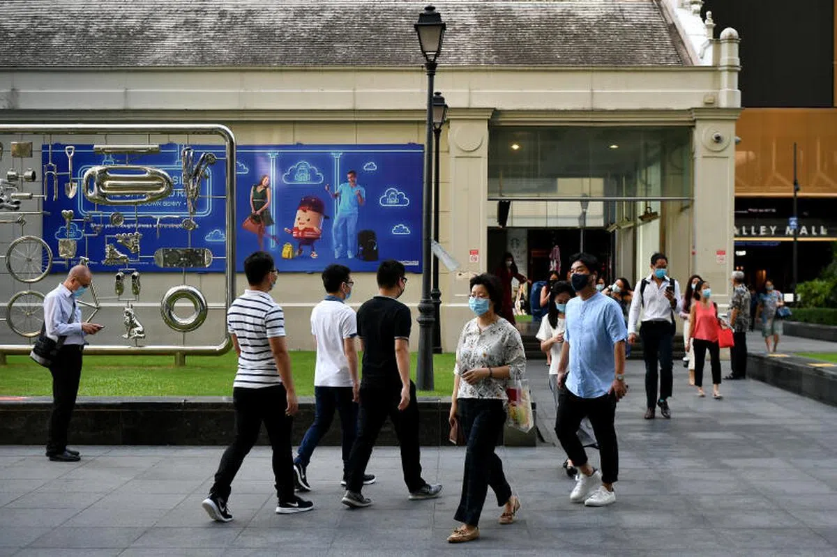 上班族在莱佛士一带行走。（海峡时报）