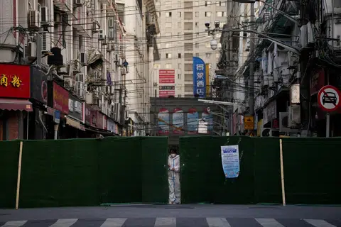 上海封城期间，防疫工作人员为一个小区锁上门。（路透社）