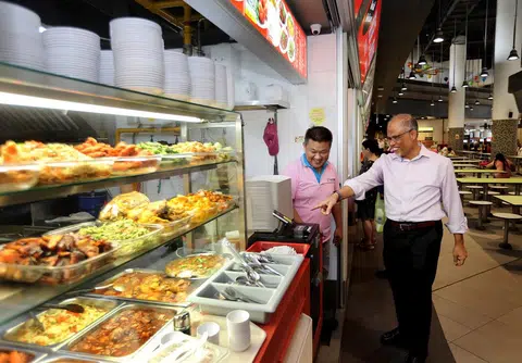 环境及水源部长马善高昨天到淡滨尼天地小贩中心用早餐，并与小贩交流了解营业情况。（联合早报）