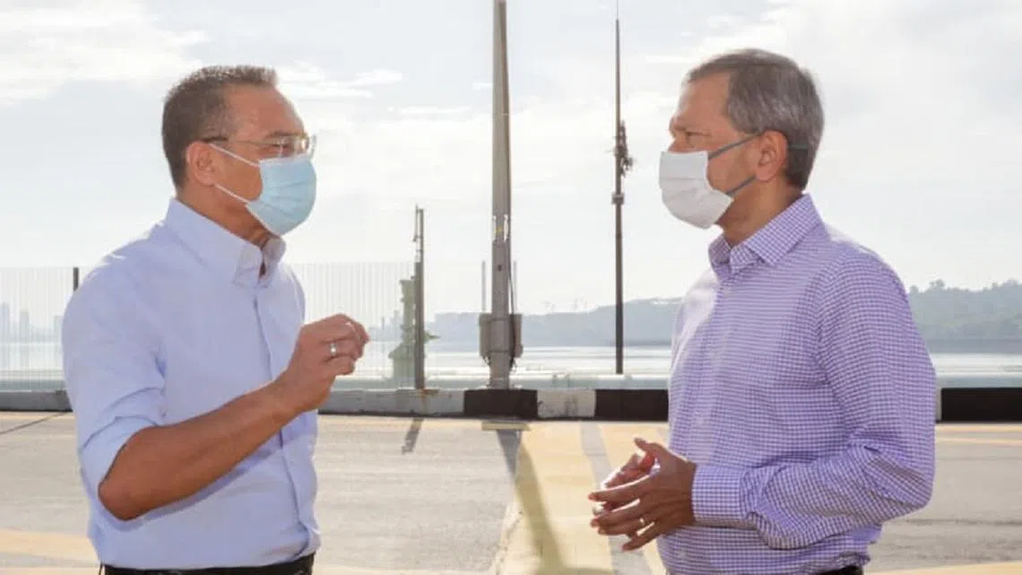 我国外交部长维文医生（右）和马来西亚外交部长希山慕丁（左）昨早在新柔长堤的中间点会晤。（外交部）