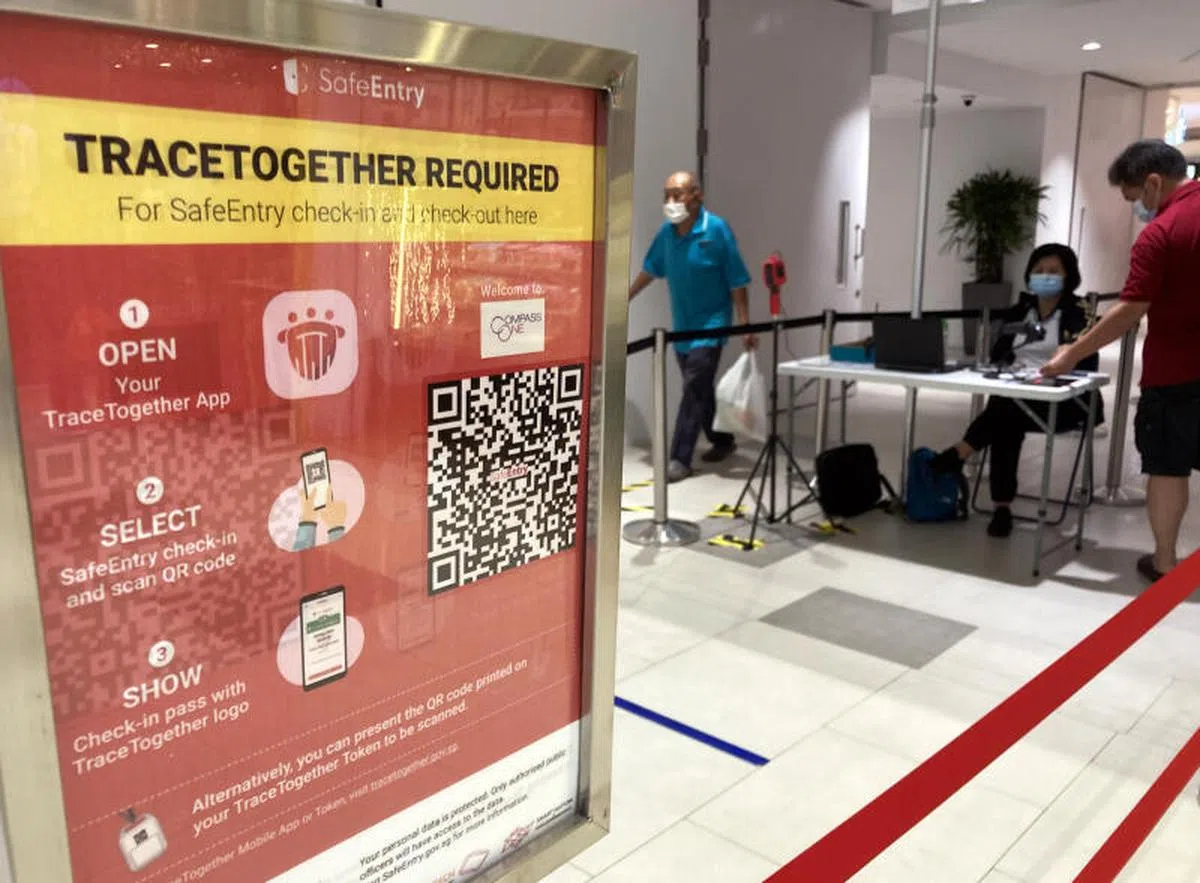  盛港勘宝坊商场入口处，访客以“合力追踪”（TraceTogether）登记入场。（联合早报） 