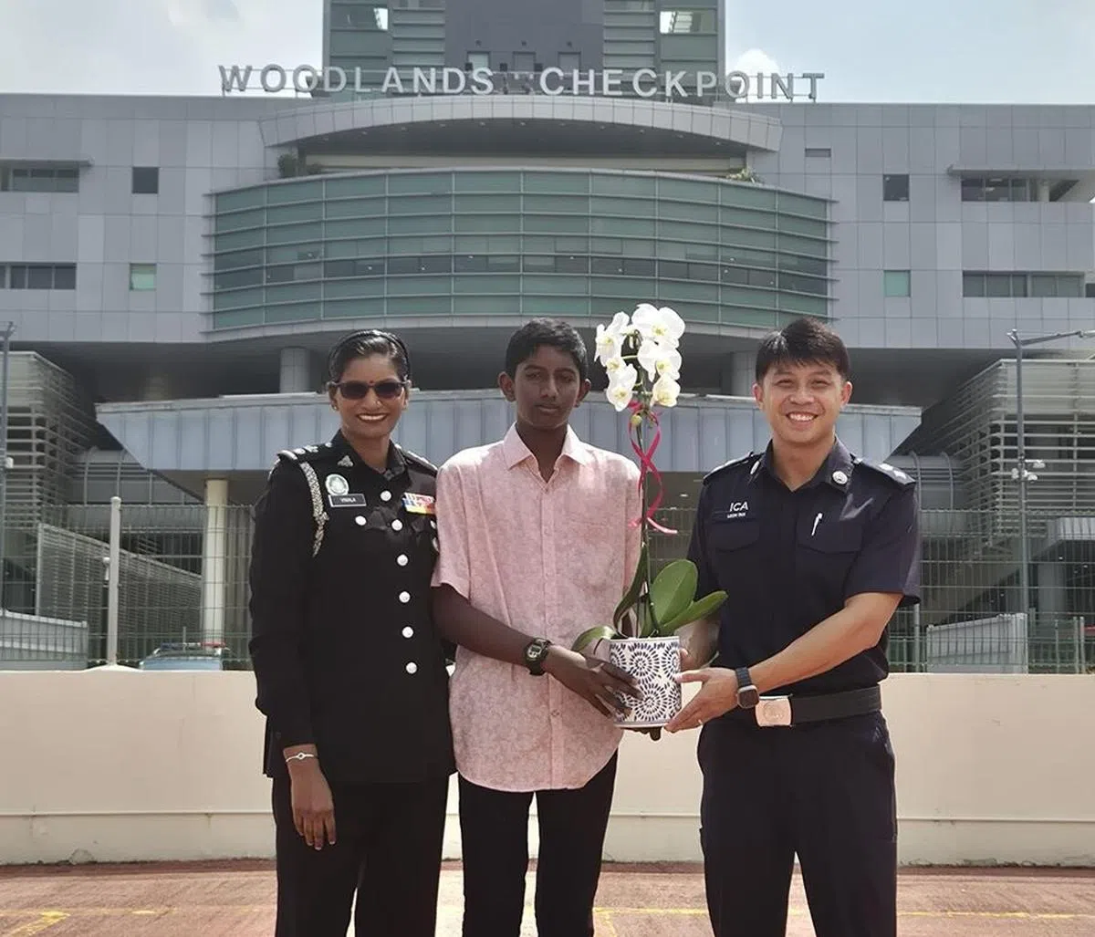 和往年送蛋糕不同，今年的礼物还多了一棵胡姬花。（新山关卡）