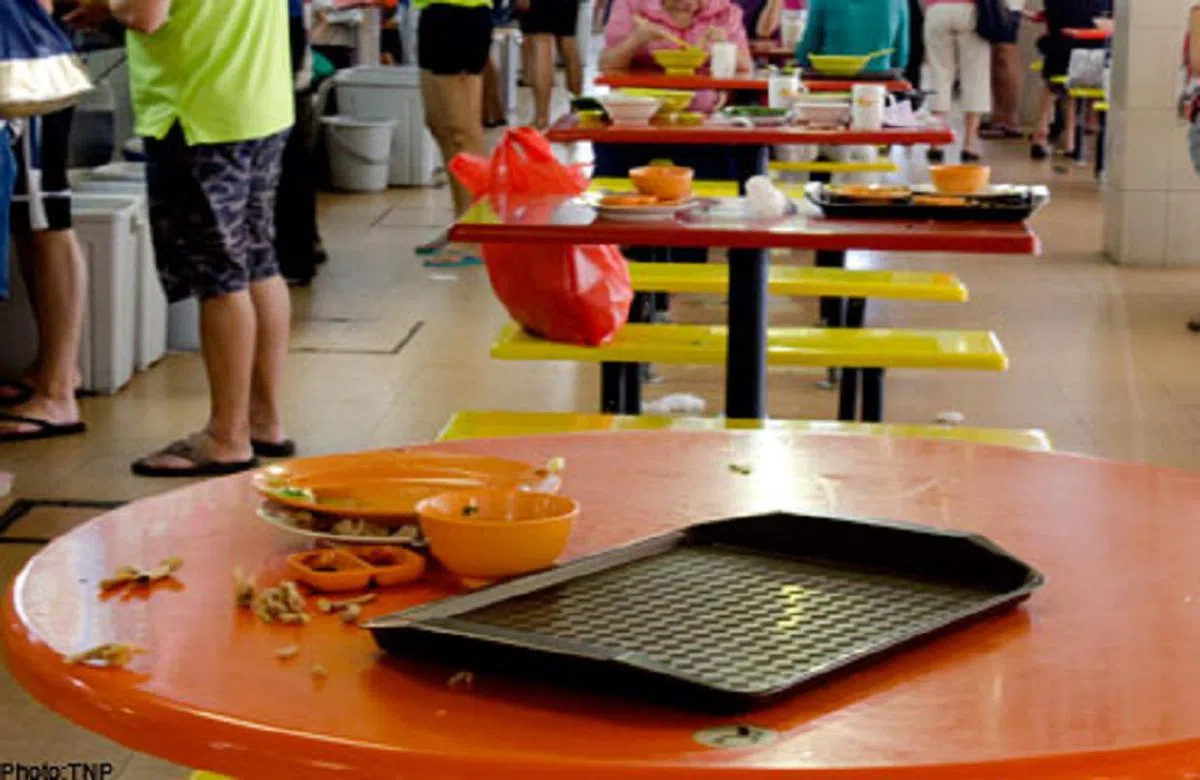  新加坡小贩中心常见的一幕：桌上杯盘狼藉，地上垃圾处处。（新报） 