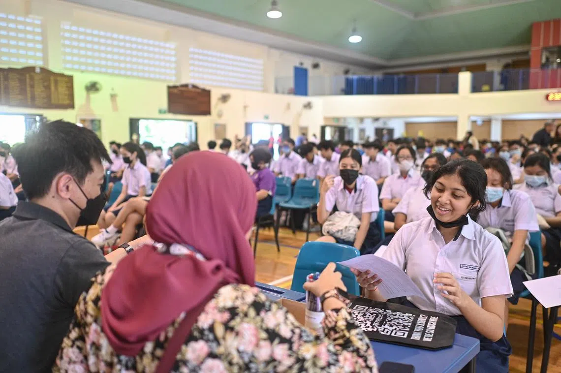 ‘O’水准会考考生从老师手中接过成绩单。（海峡时报）