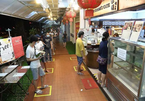 病毒阻断措施收紧之前，在蛋糕店外排队的民众。（海峡时报）