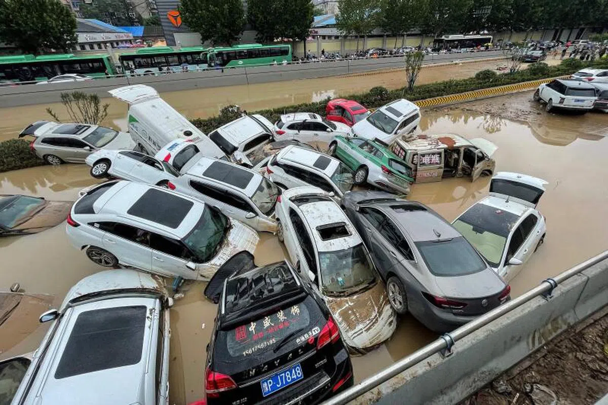 中国河南去年7月“千年一遇”暴雨导致洪灾，郑州街道上的汹涌洪水一度冲走街边车辆，令市内交通陷入停摆。（法新社）