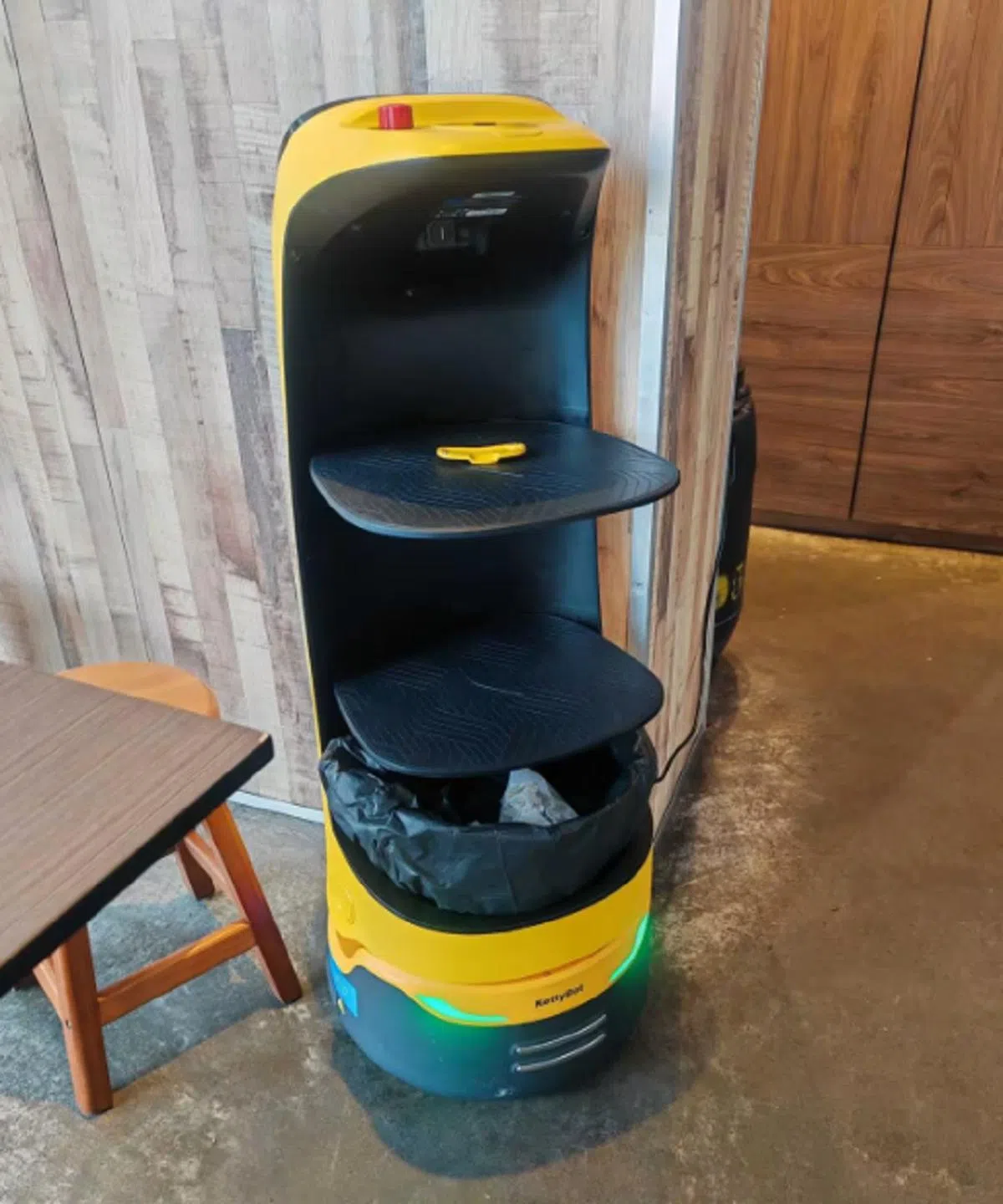 在咖啡馆“工作”的机器人体积较小，但下面多了个垃圾桶。（亚洲新闻台）