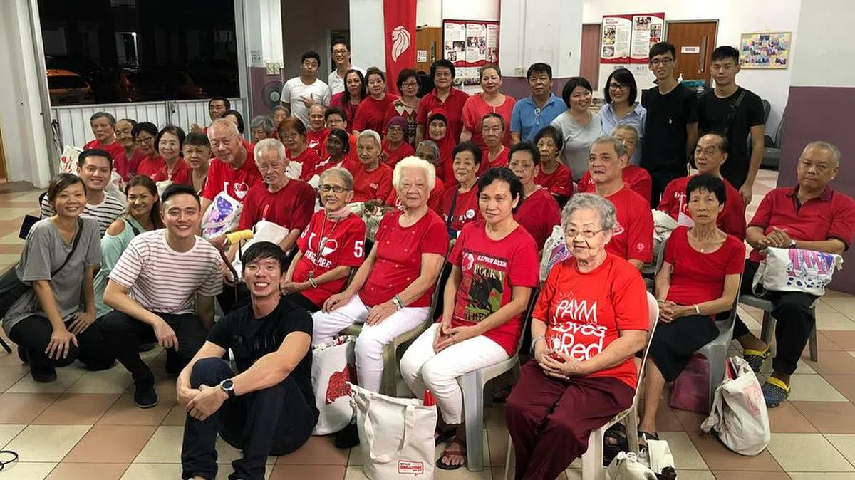  巫俊锋（第一排右二）和他的团队与胡润心（第二排右四）等乐龄人士一同观看国庆庆典的广东话版影片。（巫俊锋面簿） 