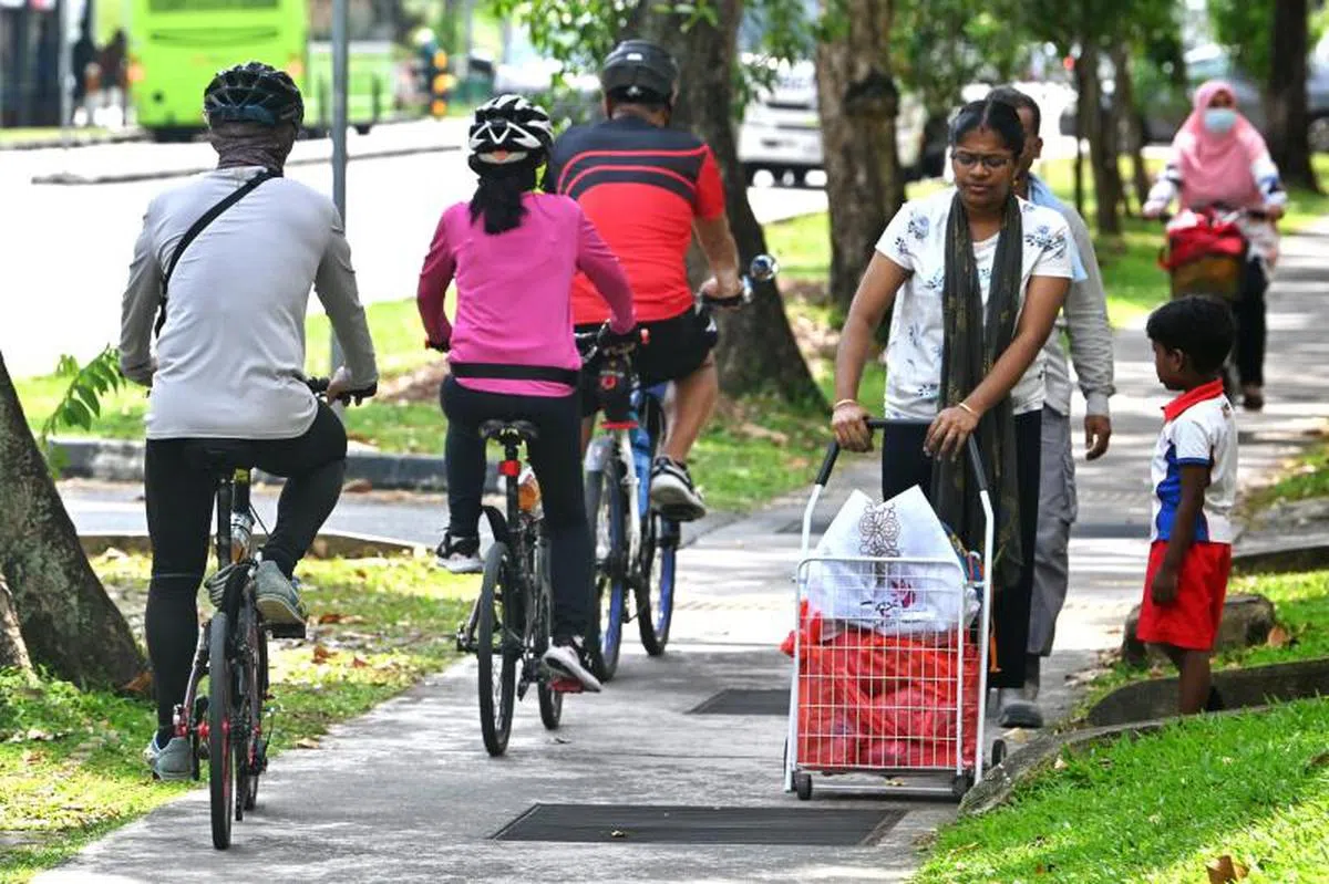 2023年1月9日，脚踏车骑士和行人在义顺环路共享人行道。（海峡时报）