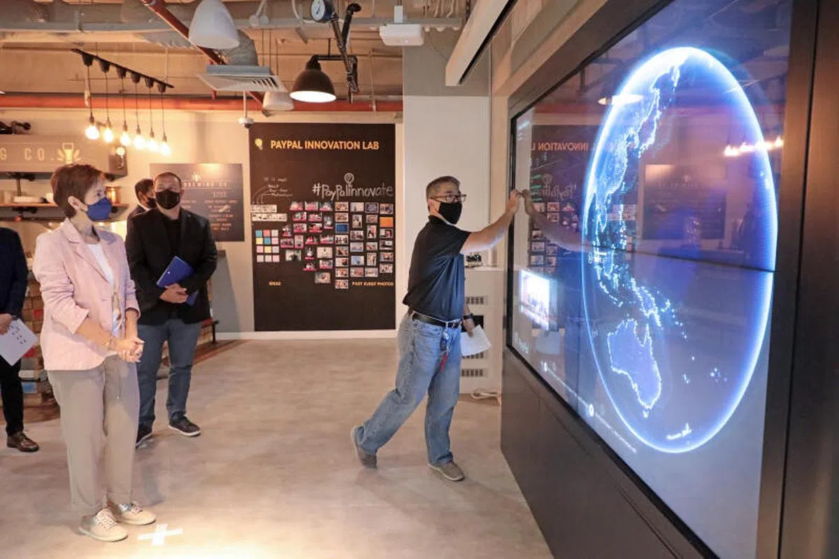  杨莉明（左）走访新加坡PayPal创新中心。（联合早报） 