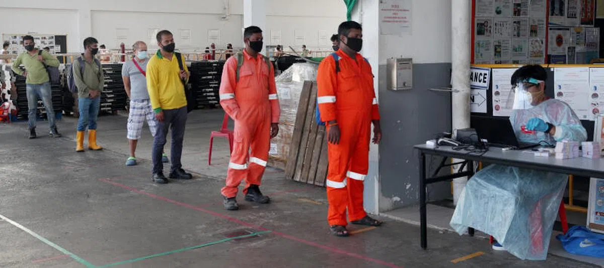  2020年8月5日，双溪登加客工宿舍（Sungei Tengah Lodge）内的客工排队领取电话卡。（海峡时报） 