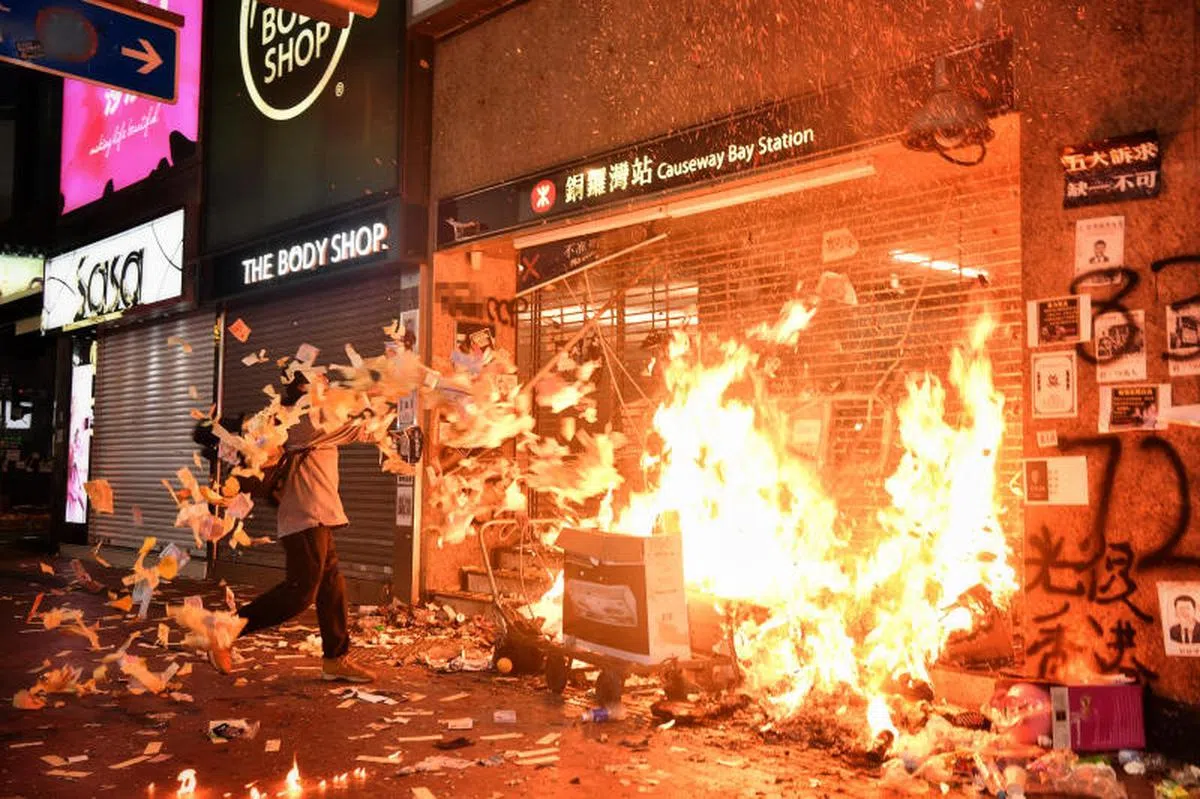  香港反修例示威延烧，一名示威者于2019年10月1日在港岛铜锣湾地铁站出口焚烧冥纸和杂物。（海峡时报） 