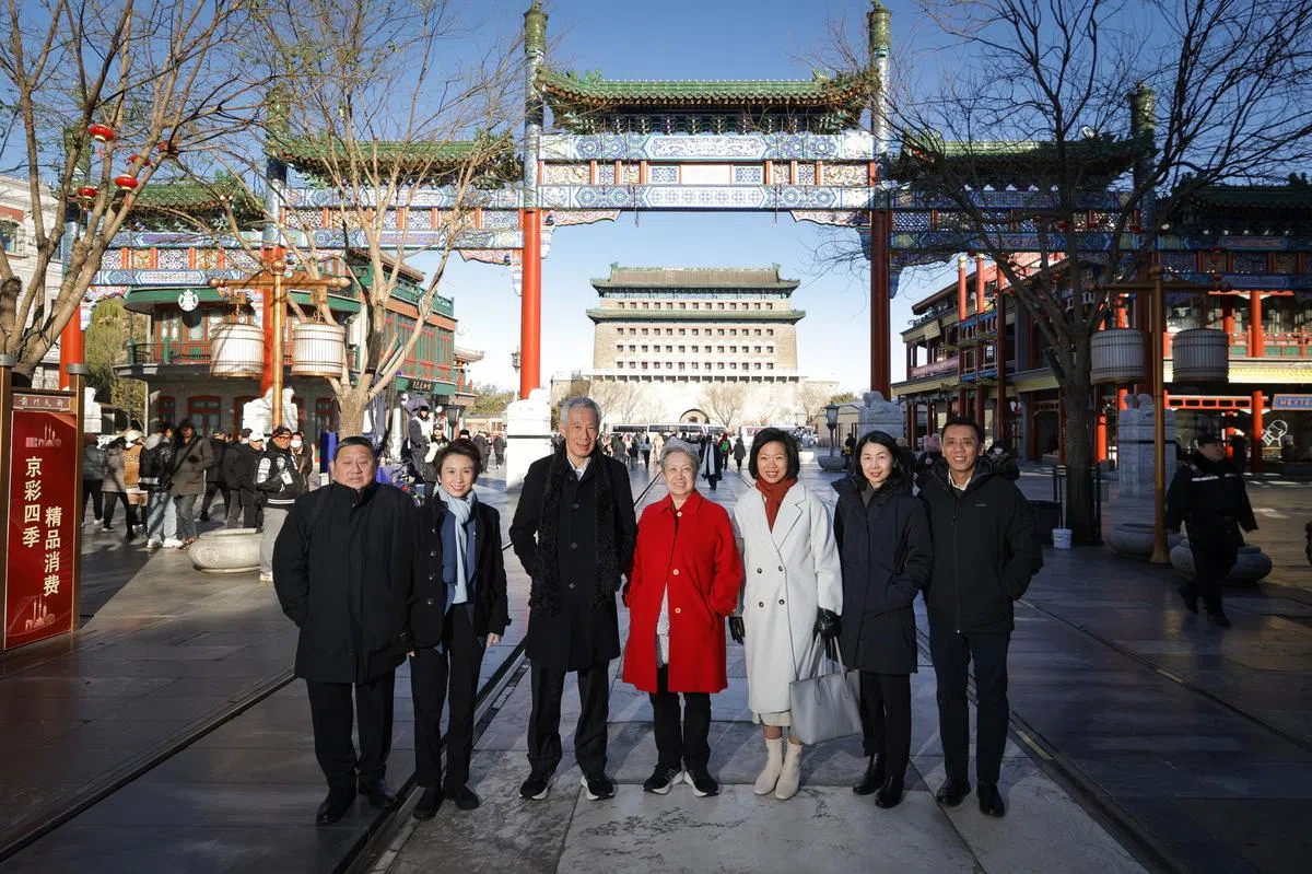 陪同李显龙资政（左三）到前门大街逛逛的包括夫人何晶（左四）、外交部兼国家发展部高级政务部长沈颖（右三）、贸工部兼文化、社区及青年部高级政务部长刘燕玲（左二），以及外交部、贸工部和总理公署官员。（李显龙脸书截图）