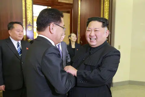 3月5日，朝鲜劳动党委员长金正恩（右一）在平壤与到访的访朝特使团团长郑义溶握手寒暄。（法新社）