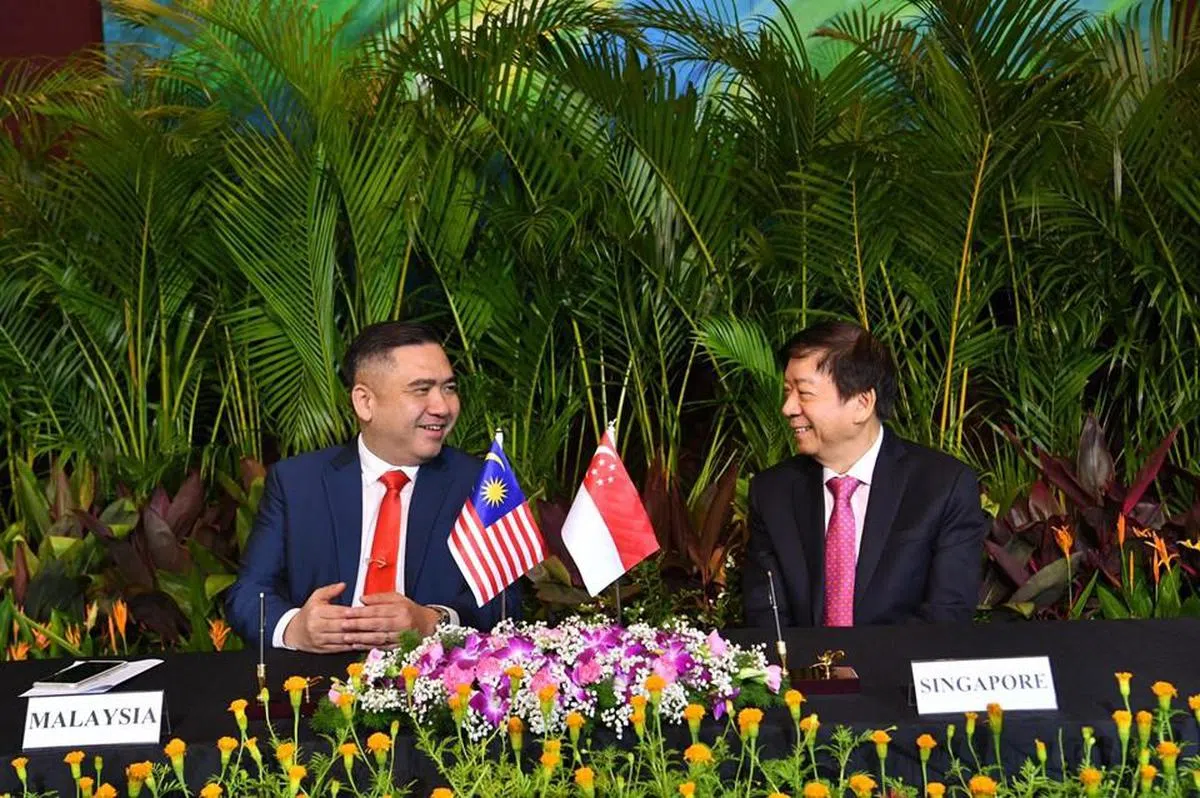  基础建设统筹部长兼交通部长许文远（右）于今年5月代表新加坡与陆兆福（左）签署补充协定。（许文远面簿） 