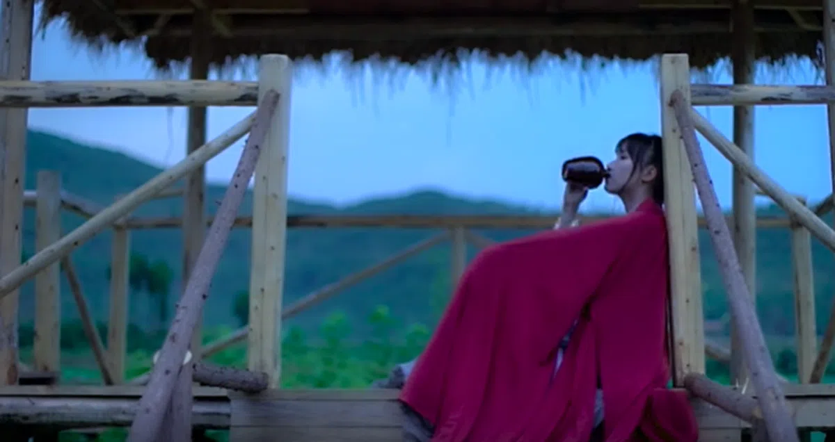  坐在亭子里喝一壶酒。（李子柒视频截图） 