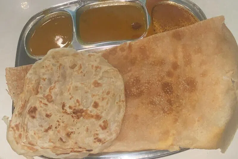 一份$3.50的印度薄饼（thosai）套餐配有咖喱汁和一块印度煎饼。