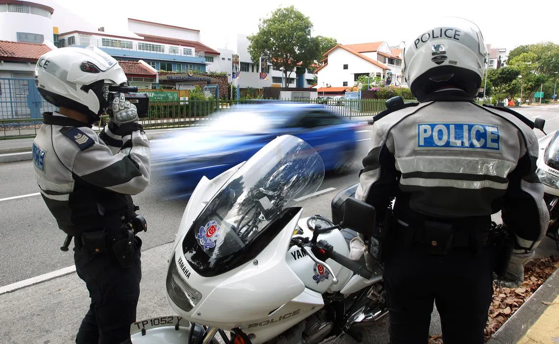 交通警察日前在淡马锡中学外展开取缔行动，使用激光测速器取缔超速驾车者。（联合早报）