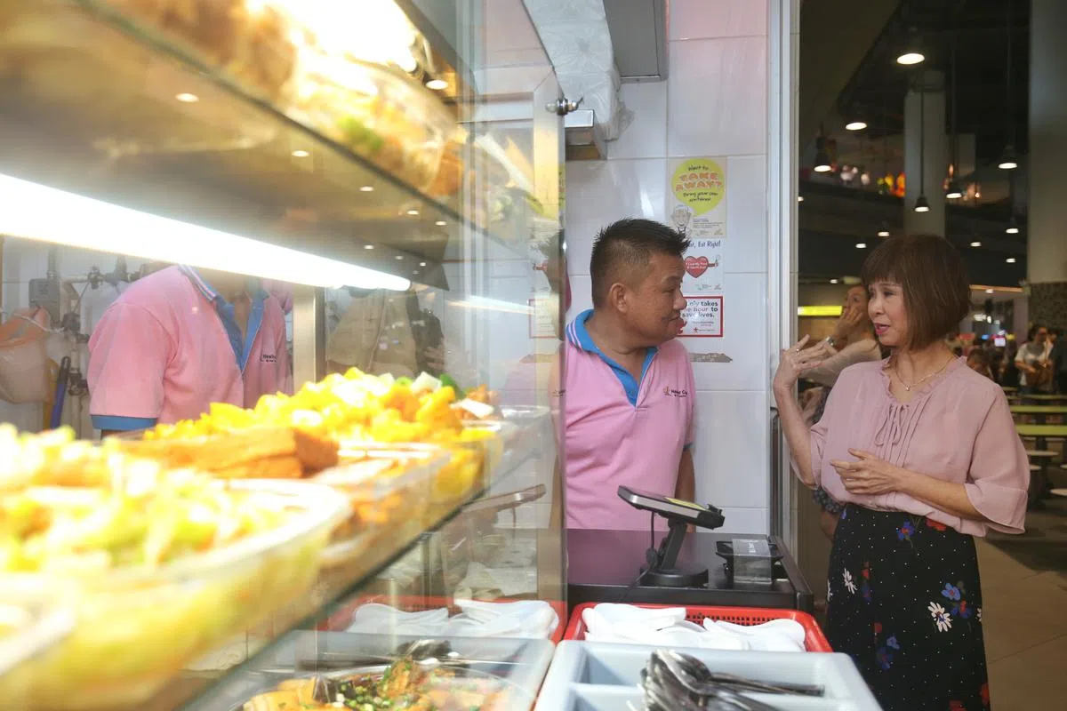  卫生部兼环境与水源部高级政务部长许连碹博士（右）本月19日表示，已要求环境局检讨社会企业小贩中心模式，若发现不合理，将会追究。（联合早报） 