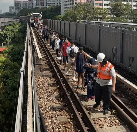 9月25日，东西线金文泰地铁站附近因故障而停滞的地铁列车上，有850名乘客被迫沿着轨道走回站台。（SMRT脸书）