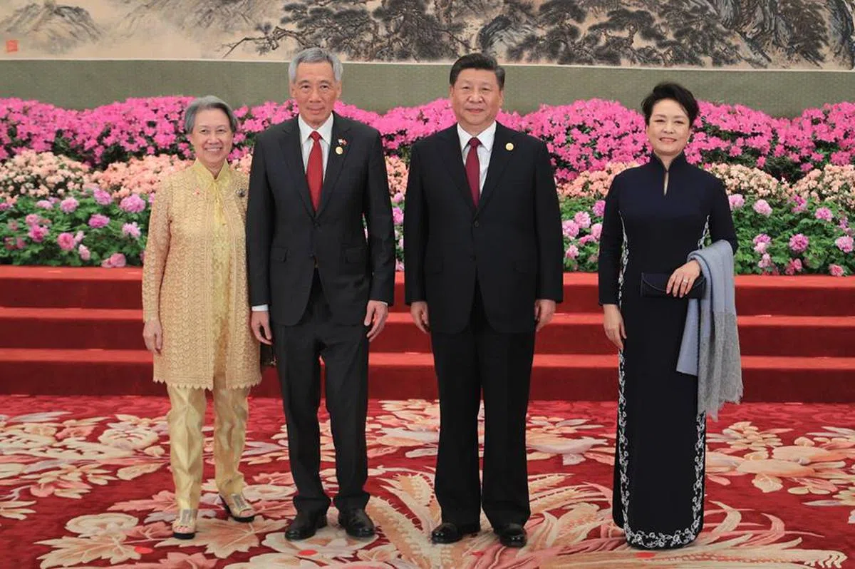  总理夫人，你好像站得太靠近总理了？“一带一路”国际合作高峰论坛在4月26日开幕后，李显龙总理（左二）与夫人何晶（左一）出席在人民大会堂举行的领导人欢迎晚宴，两人与中国国家主席习近平（右二）与夫人彭丽媛合影。（李显龙面簿） 
