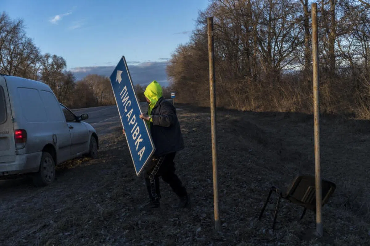 2022年2月26日，一名乌克兰工人在乌克兰卡列尼夫卡（Kalynivka）拆除路标。（纽约时报）