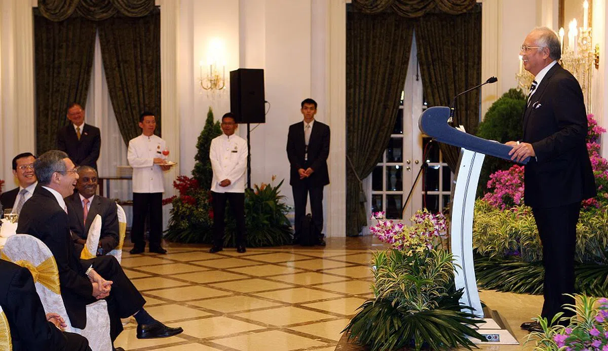 2009年5月22日，马国前首相纳吉（右）面对着坐在主桌的李显龙总理和时任国务资政兼国家安全统筹部长贾古玛教授，在总统府举行的晚宴上致答词。（海峡时报档案照）