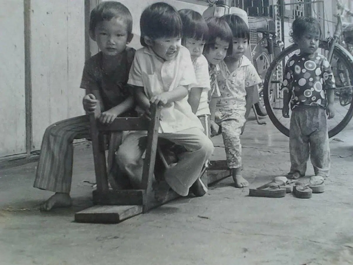  马来西亚家门前是我们的乐园，将长椅反转当汽车，准备扬长而去。（作者提供） 