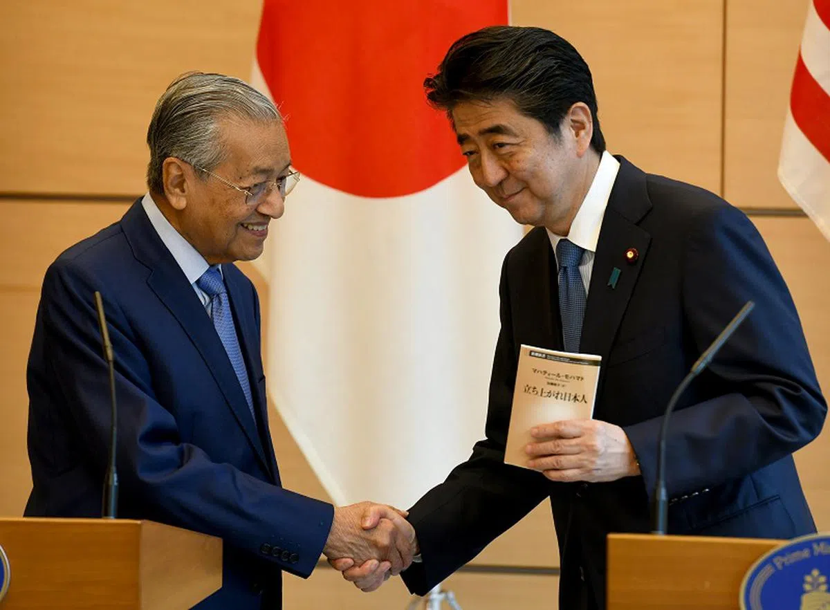  马哈迪与安倍握手言欢。（法新社） 