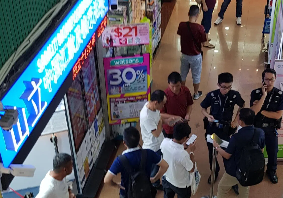 受影响的中国客工向汇款公司讨要说法。（新明日报）