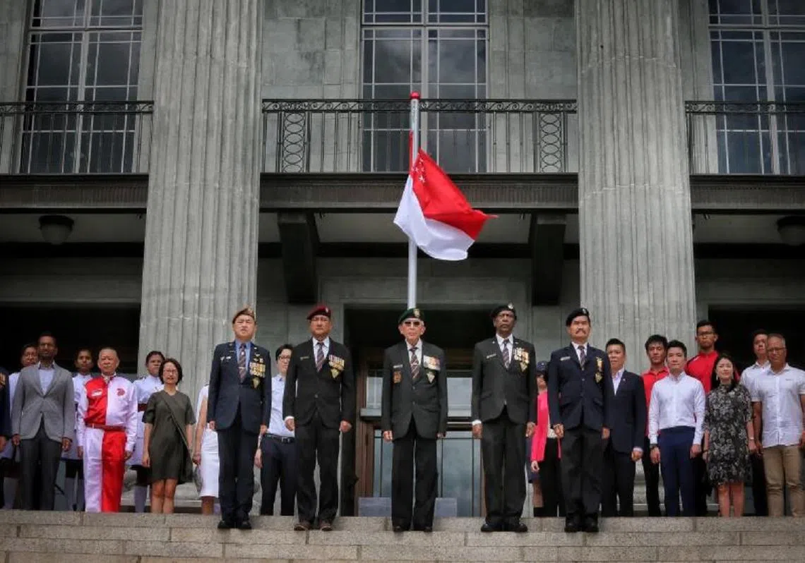 不同背景的国人齐聚一堂，进行“国家象征”推出60周年纪念典礼。（联合晚报）