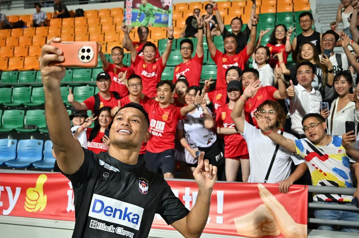 哈山6月15日在赛事结束后，于惹兰勿刹体育场与现场的中国球迷合影。（海峡时报）
