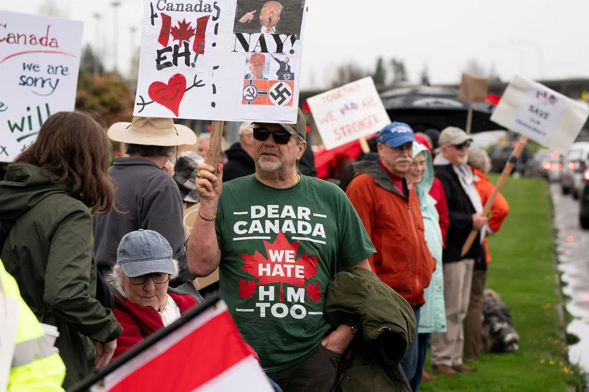 美国和加拿大人民4月6日在两国边境举行名为“和平、爱与握手”的团结集会。（路透社）