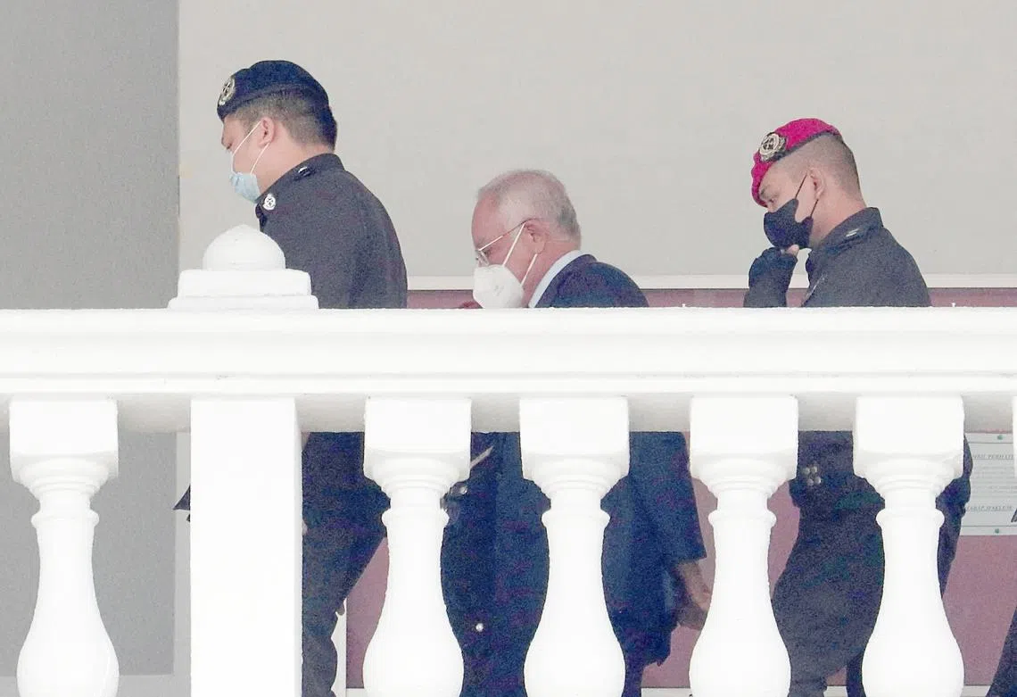 沦为阶下囚的纳吉（中）8月25日在监狱人员押送下，出庭接受另一项审讯。（路透社）