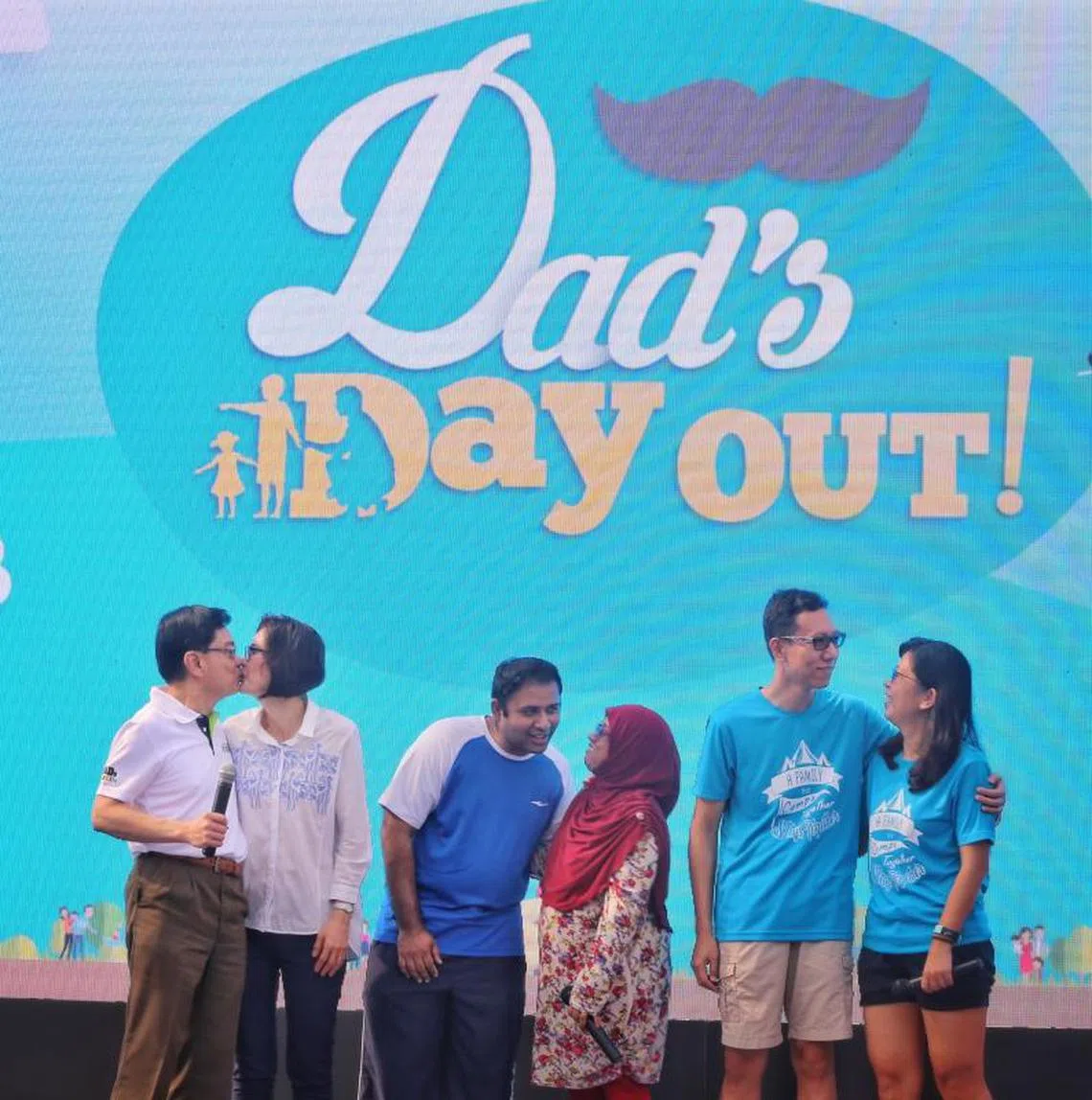 王瑞杰（左一）和太太章慧霓（左二）16日携手出席在体育城举办的父亲节活动，并两度亲吻对方，以感谢彼此为孩子和家庭所付出的努力。（联合早报）