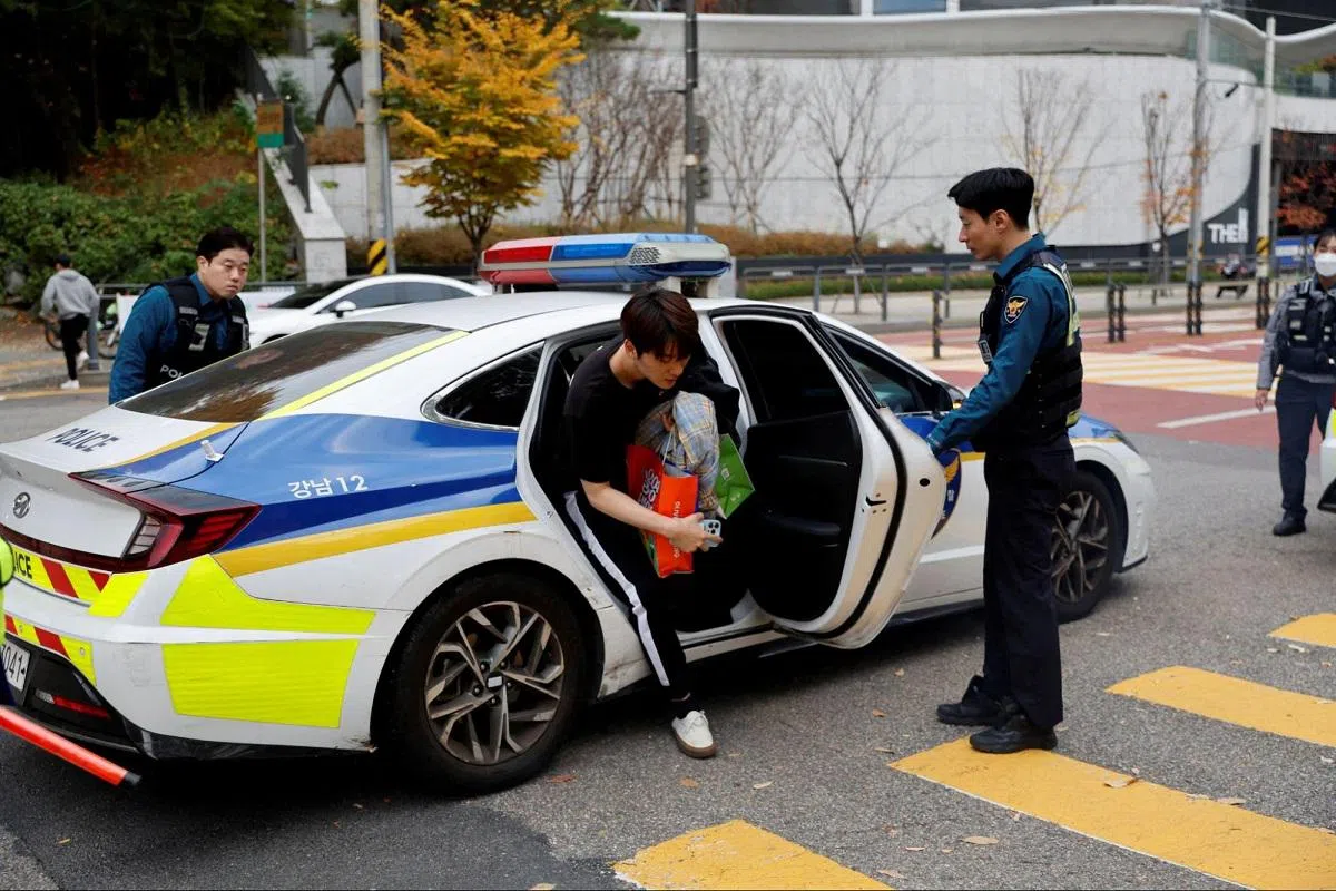 一名考生在韩国警察的护送之下前往考场。（路透社）