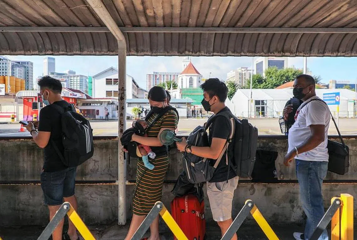 在新加坡奎因街等候VTL短程巴士前往柔佛新山的民众。（联合早报）