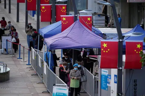 上海市民在一处核酸检测站排队等候接受检测。（路透社）