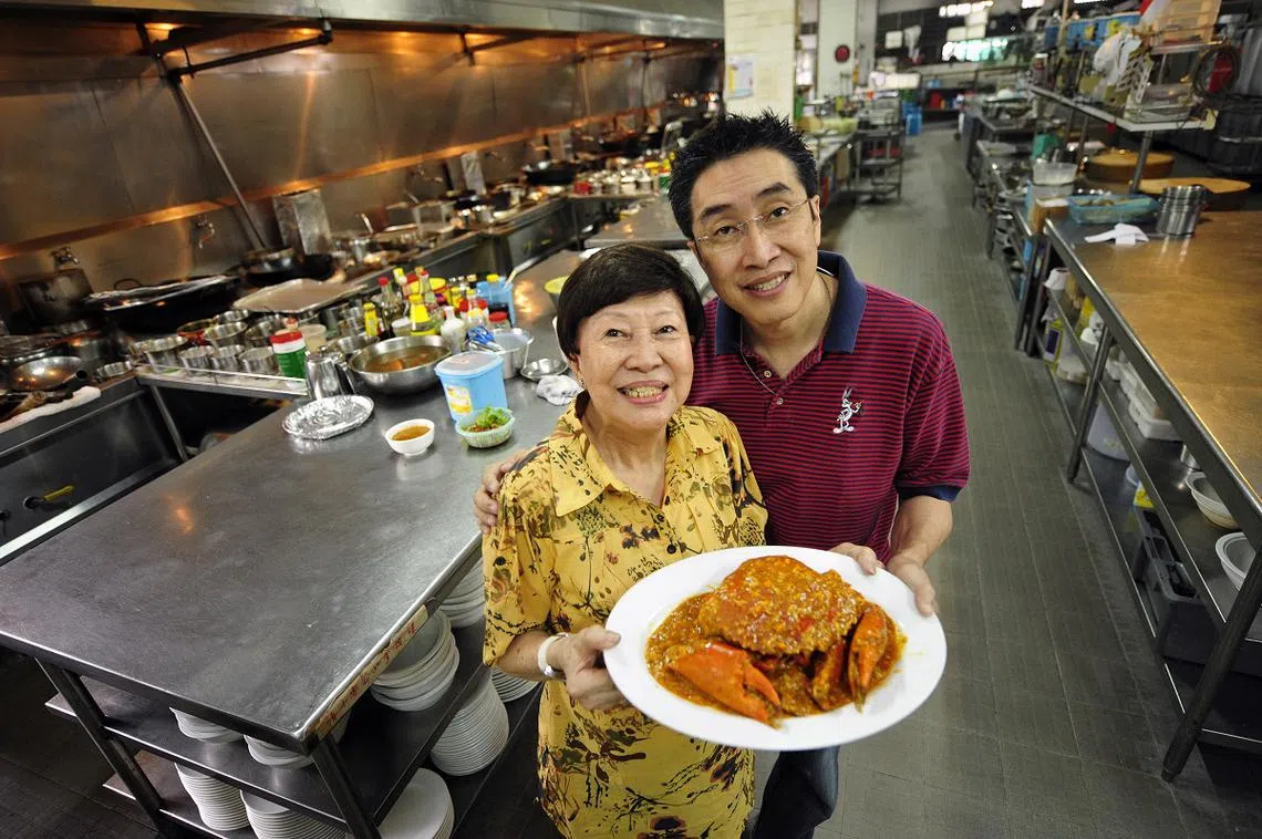 东皇海鲜楼创办人林罗伦（右）继承母亲徐炎珍的衣钵，该餐馆目前仍售卖原味番茄辣椒螃蟹。（海峡时报档案照）