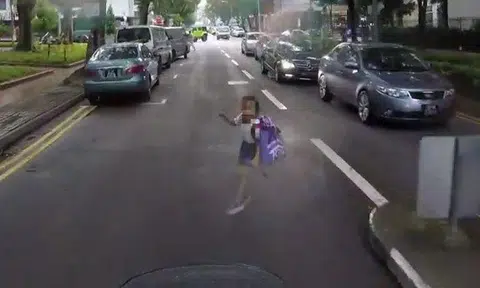 Young girl narrowly avoids disaster after running in front of oncoming motorcycle