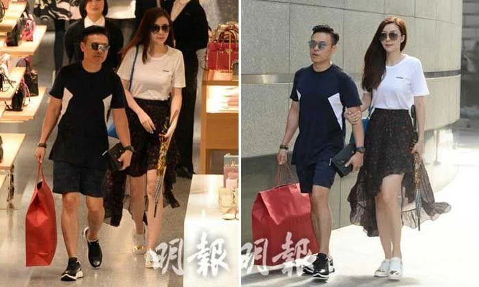 Lynn Hung's husband sits patiently while she chooses handbag