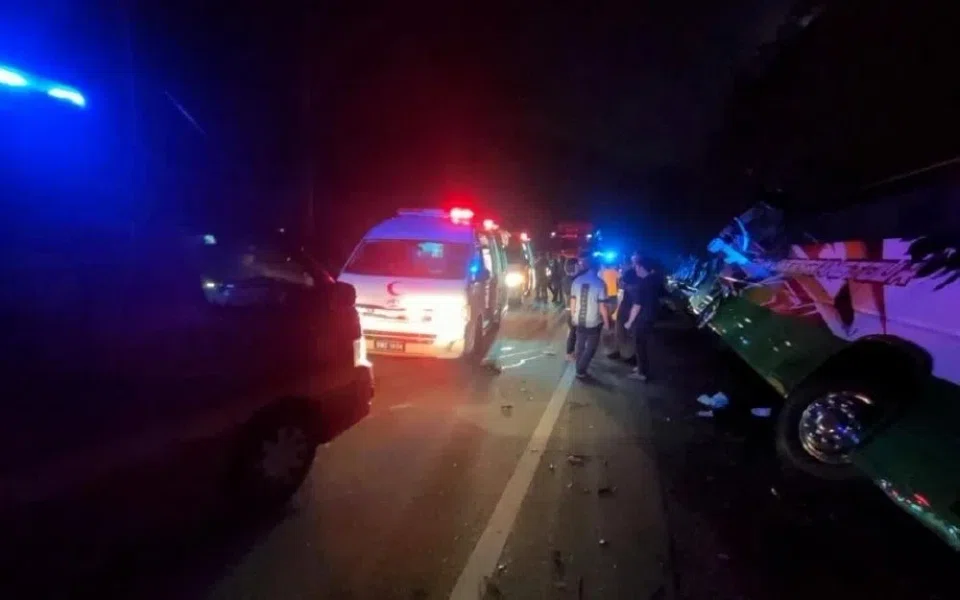 Photos of the aftermath show an overturned bus and passengers standing on the side of the road waiting for rescue.