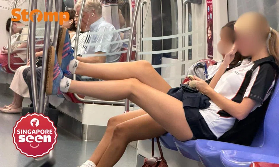 The passenger was seated with her legs outstretched and her Adidas-covered feet resting on the vertical metal pole.