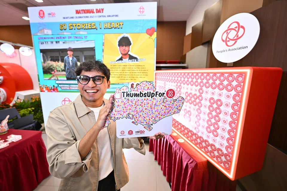 Mr Mohammed Salihan Wahid, 27, holding up a miniature version of the Thumbs Up for SG60! artwork at the Central Singapore booth.