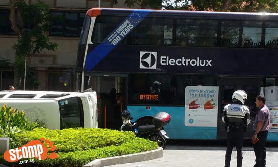 Van left lying on its side after colliding with bus near Raffles City ...