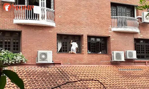Woman kneels on narrow ledge to clean windows at Kheam Hock Road condo
