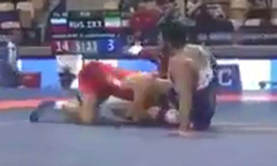 Iranian wrestler Alireza Karimi Mashian (in blue) in his bout against Russia's Alikhan Zabrailov (in red).