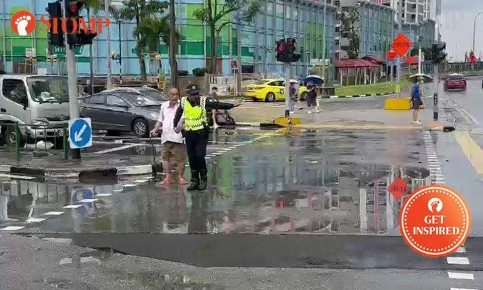 Aetos officer helps elderly man cross road in Ang Mo Kio despite being drenched by rain