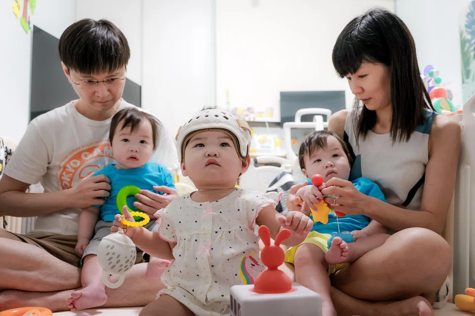 Ng Pei Xuan, one, is part of a set of triplets. She has flat-head syndrome from continuously sleeping on one side, which resulted in her having to wear a corrective helmet.