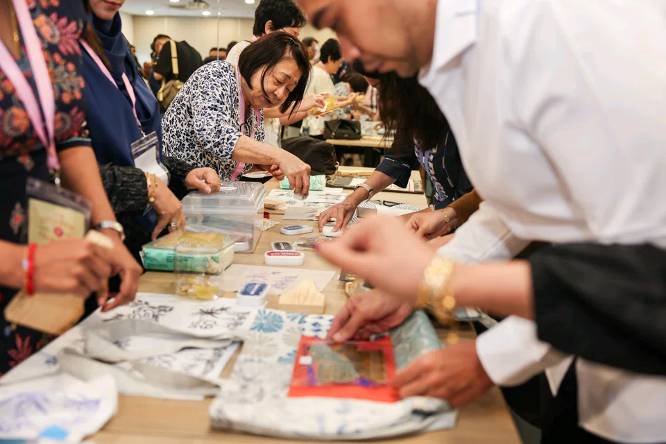 Invited guests stamping different SG60 designs onto the tote bags of their choice during the launch of the Tote-rific Community initiative.